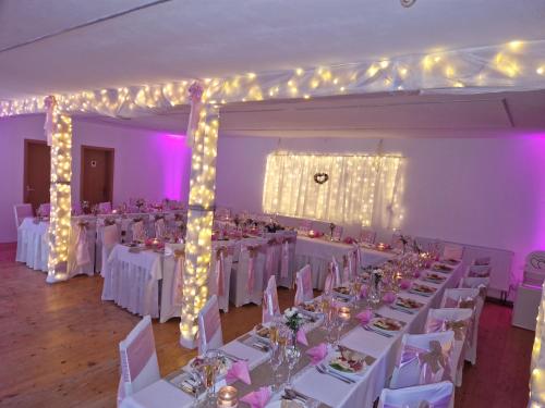 a banquet hall with white tables and chairs and lights at Pension St. Maria in Staré Hory