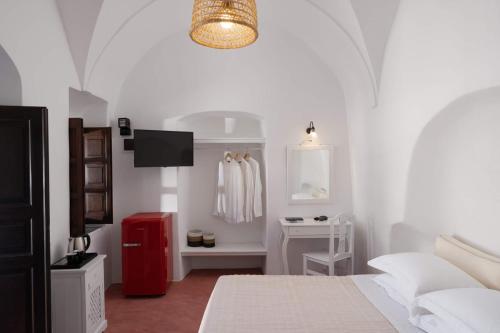 a white bedroom with a bed and a red refrigerator at Kalitsi Canaves in Vóthon