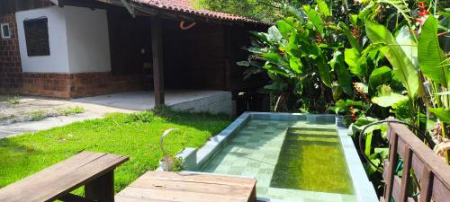 a small swimming pool in the yard of a house at Cabana na cachoeira do 18 in Gravatal