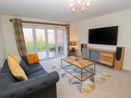 a living room with a couch and a flat screen tv at 4 Centurion Rise in Penrith