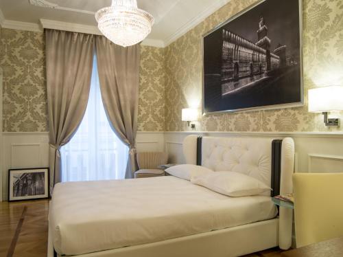 a bedroom with a bed and a chandelier at Duomo Rooms in Milan