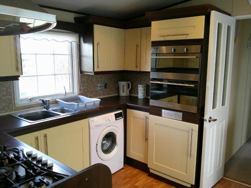 a kitchen with a sink and a washing machine at The Wolds Westwood 6 Berth, Central Heated in Ingoldmells