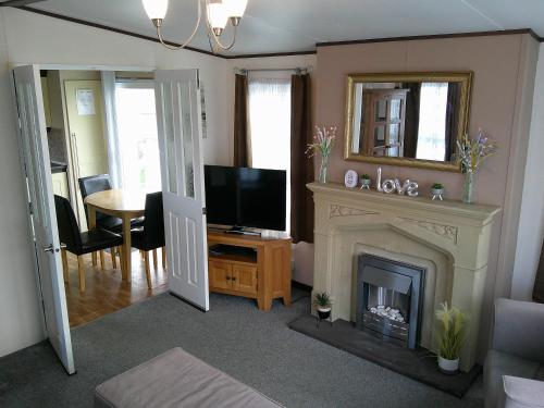a living room with a fireplace and a television at The Wolds Westwood 6 Berth, Central Heated in Ingoldmells
