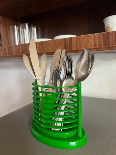 a green container filled with spoons and forks on a counter at The Villa Sea Breeze in Talpe