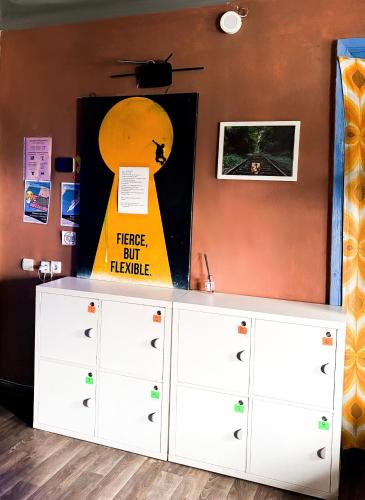 a white cabinet against a wall with a sign on it at Mouse House in Chişinău