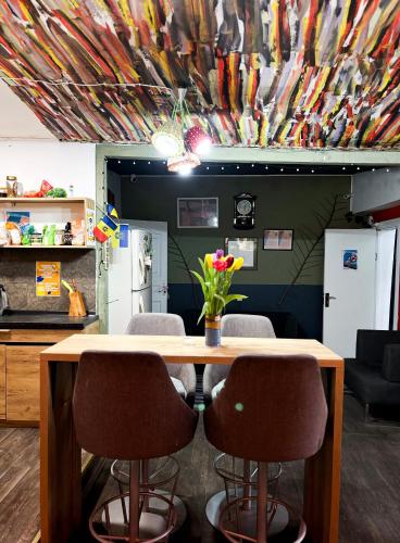 a table with chairs and a vase of flowers on it at Mouse House in Chişinău