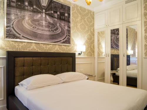 a bedroom with a bed and a picture on the wall at Duomo Rooms in Milan
