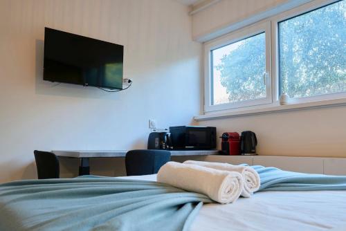 - une chambre avec un lit et une télévision murale dans l'établissement Studio tout confort, à Tourcoing