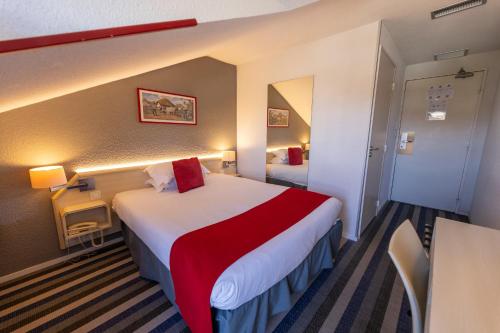 a hotel room with a large bed with a red blanket at Hotel Donibane Saint-Jean-de-Luz in Saint-Jean-de-Luz