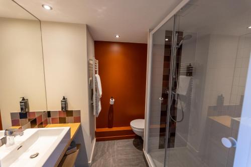 a bathroom with a toilet and a glass shower at Hotel Donibane Saint-Jean-de-Luz in Saint-Jean-de-Luz