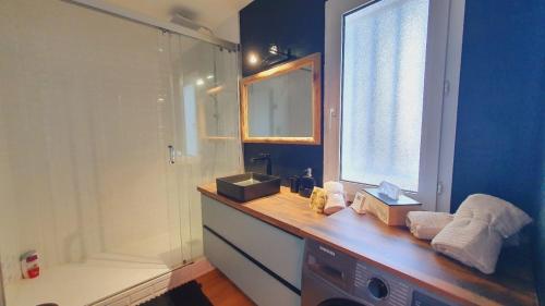 La salle de bains est pourvue d'une douche et d'un comptoir en bois. dans l'établissement T3 Plage du Golf Piscine WIFI - ROSSIconciergerie - Linge inclus, à La Grande Motte