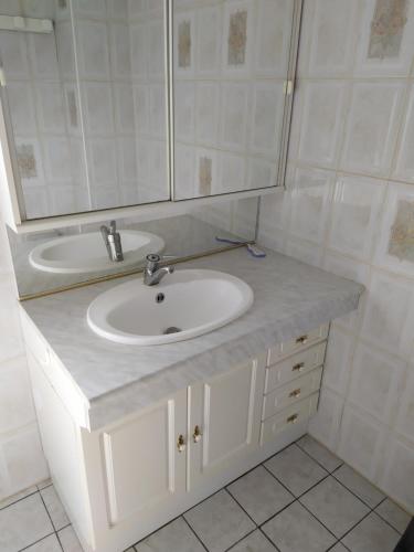 une salle de bain avec un lavabo et un miroir dans l'établissement La maison du pêcheur, à Saint-Martin-de-Sanzay