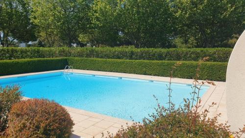 une grande piscine bleue dans un jardin dans l'établissement T3 Plage du Golf Piscine WIFI - ROSSIconciergerie - Linge inclus, à La Grande Motte