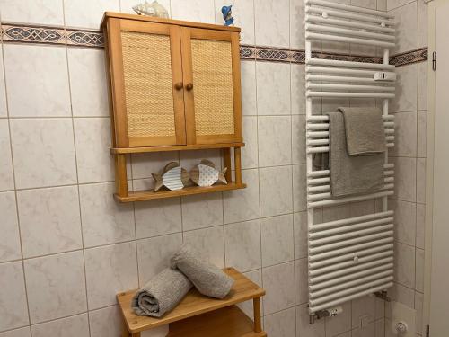 a bathroom with a wooden cabinet and towels at Gemütliche strandnahe Ferienwohnung in Bansin