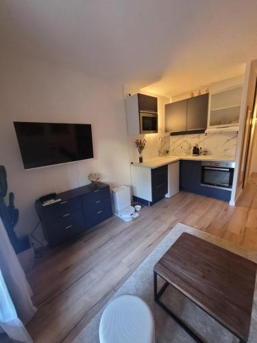 un salon avec une table et une cuisine dans l'établissement Appart avec jardin proche mer, à La Ciotat