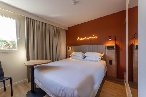 a hotel room with a large bed and a desk at Hotel Donibane Saint-Jean-de-Luz in Saint-Jean-de-Luz