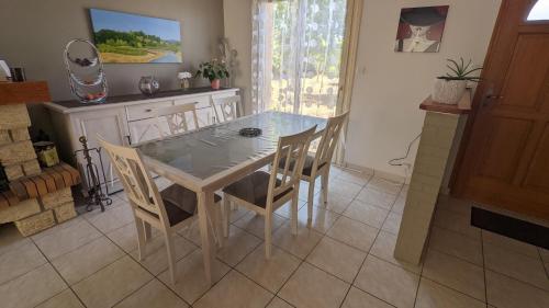 une salle à manger avec une table et des chaises en verre dans l'établissement La chambre d'Etriel, à Saint-Nicolas-de-Redon
