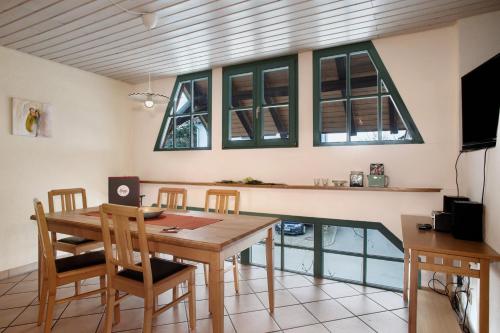 a dining room with a table and some windows at Obst- Ferienhof Ragg in Immenstaad am Bodensee