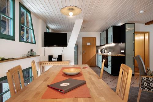 a kitchen and dining room with a table with a laptop on it at Obst- Ferienhof Ragg in Immenstaad am Bodensee