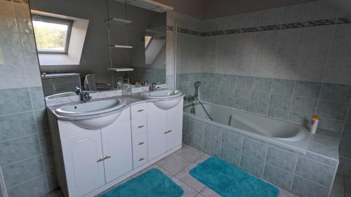 une salle de bain avec deux lavabos et une baignoire dans l'établissement La chambre d'Etriel, à Saint-Nicolas-de-Redon