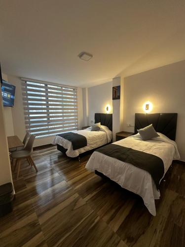 una camera da letto con due letti e una finestra di Bastille Hotel a Sucre
