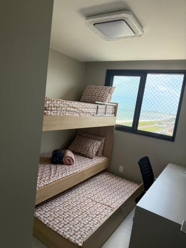 a room with three bunk beds with a person sleeping on them at Gerizim in Vila Velha