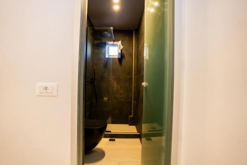 a bathroom with a toilet and a glass door at Zen Suites & Spa in Perissa