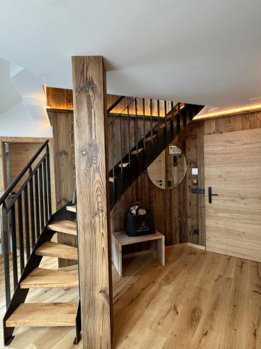 a staircase in a house with wooden walls and wooden floors at Gipfelhaus Magdalensberg in Sankt Veit an der Glan