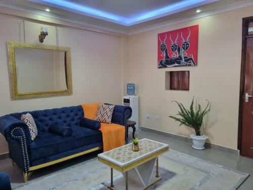 a living room with a blue couch and a mirror at D & C Homes in Eldoret