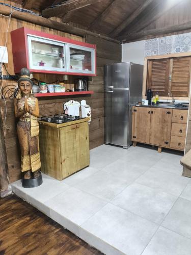 a kitchen with a statue of a woman on a counter at Cabana na cachoeira do 18 in Gravatal