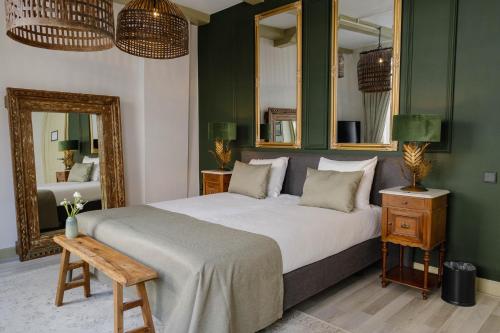 a bedroom with a large bed and a mirror at Grand Boutique Hotel-Restaurant Huis Vermeer in Deventer