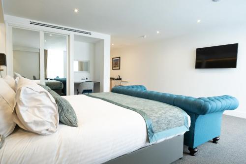 a bedroom with a large bed and a mirror at Dale Hill Hotel in Ticehurst