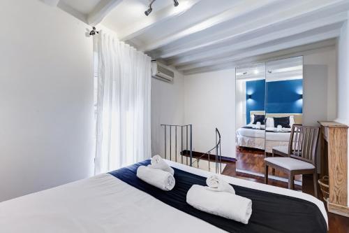 - une chambre avec un grand lit et 2 serviettes dans l'établissement Vivilo Collection - Macelli Spanish Steps Apartment, à Rome
