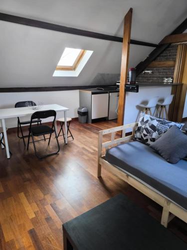 a living room with a couch and a table at Appart 3 sous combles in Bray-Dunes
