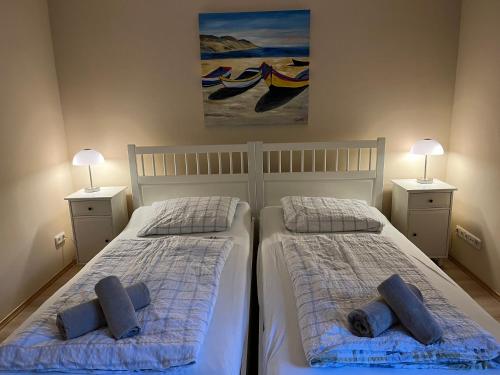 two beds in a bedroom with two lamps on both sides at Gemütliche strandnahe Ferienwohnung in Bansin