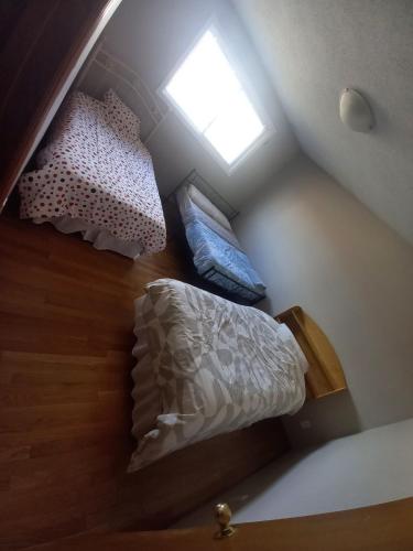 an attic bedroom with two beds and a window at Affordable Family Room for 4 People-24Hrs Checkin-Next To Downtown,Airport in Kitchener