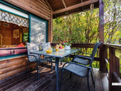 a table and chairs on the porch of a cabin at נופש מרום - 4 בקתות כפריות עם בריכה, ג'קוזי וסאונה in Ma'ale Gamla