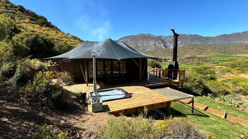 a gazebo with a roof on a hill at Ontevreden Farm in Montagu