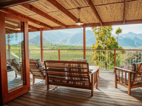 a porch with benches and a view of mountains at Ontevreden Farm in Montagu