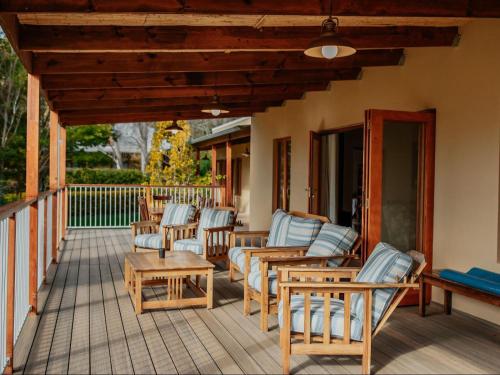 a deck with lounge chairs and a table at Ontevreden Farm in Montagu