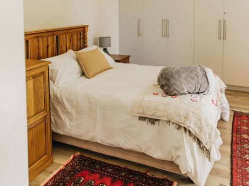 a bedroom with a large bed with a wooden headboard at Ontevreden Farm in Montagu