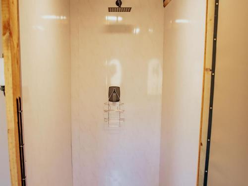 a white bathroom with a shower with a toaster on the wall at Ontevreden Farm in Montagu