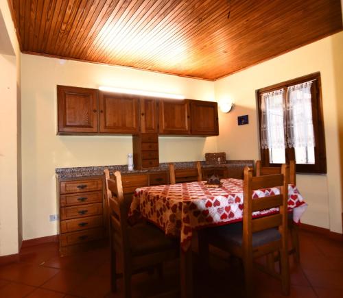 a kitchen with a table and wooden cabinets at Appartamento Vetta Cremolino in Cremolino