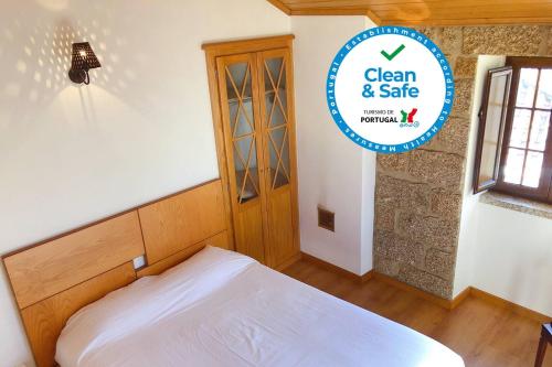 a bedroom with a bed and a sign that says clean and safe at Laje House Fireplace entire house wifi in Fundão