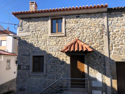 a stone building with a tile roof and a staircase at Laje House Fireplace entire house wifi in Fundão