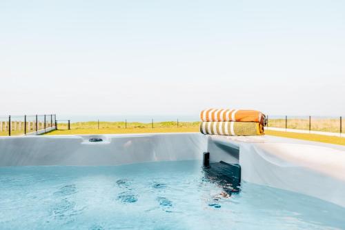 une baignoire jacuzzi avec une serviette et une plage dans l'établissement Villa Bellevue, à Donville-les-Bains