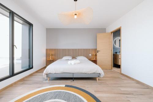 a bedroom with a bed and a large window at Villa Bellevue in Donville-les-Bains