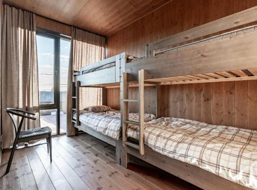 a bedroom with two bunk beds in a wooden wall at Luxury apartment, 8 beds, sauna, 10 min to ski slopes in Idre