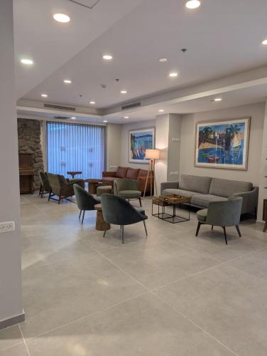 a waiting room with couches and chairs and tables at Astoria Galilee Hotel in Tiberias