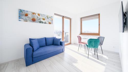 salon z niebieską kanapą i stołem w obiekcie Apartamenty Sun & Snow BLUE II w Sarbinowie